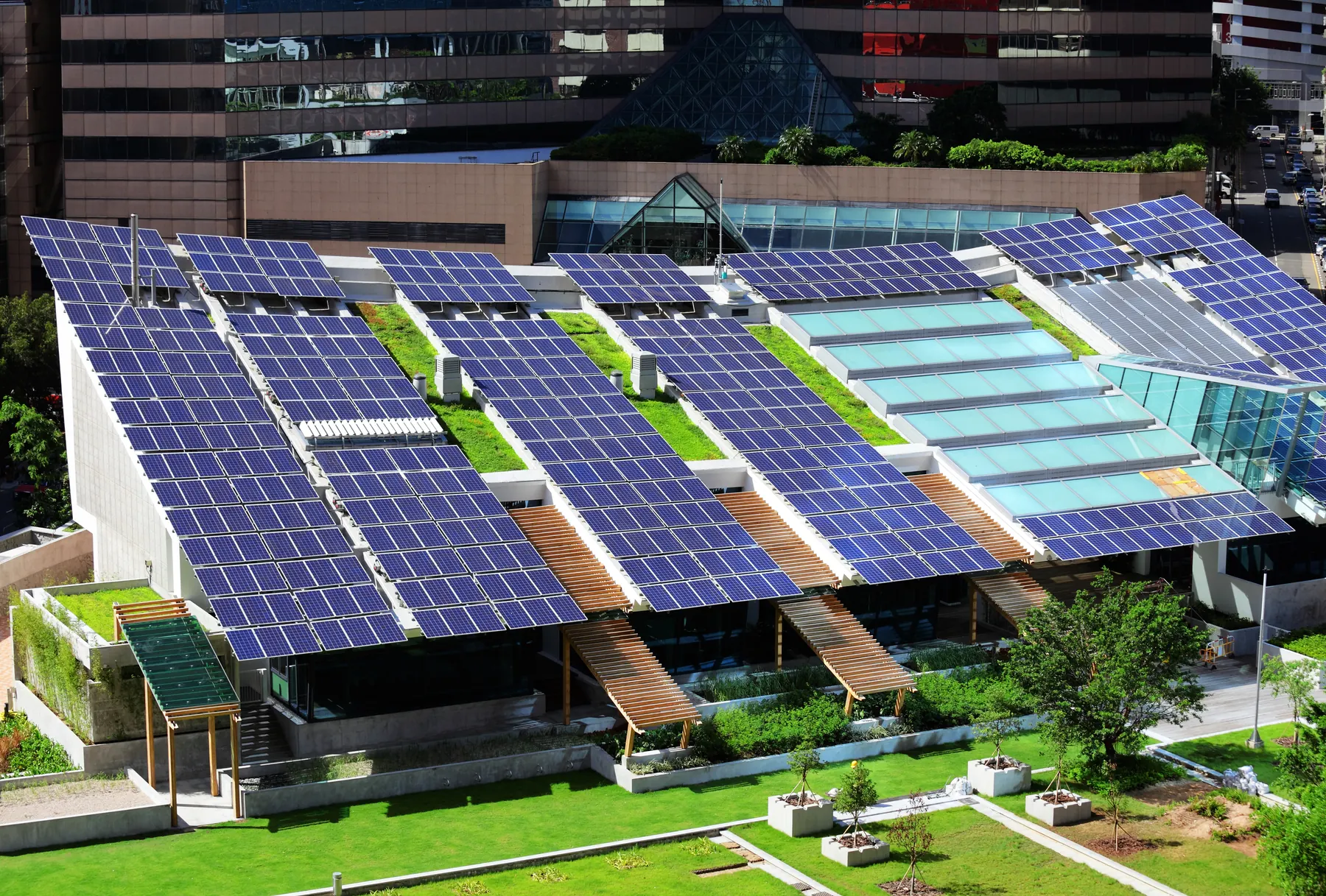 An urban building with photovoltaic panels, planted roof areas and glazed rooflights.